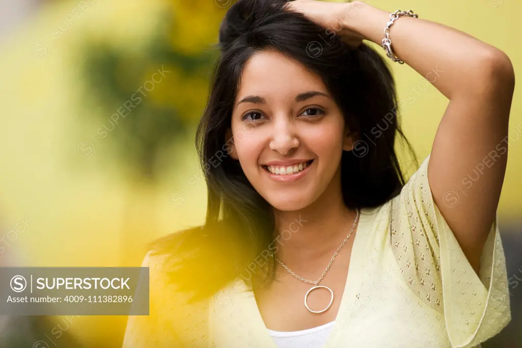 Smiling Hispanic woman holding hair