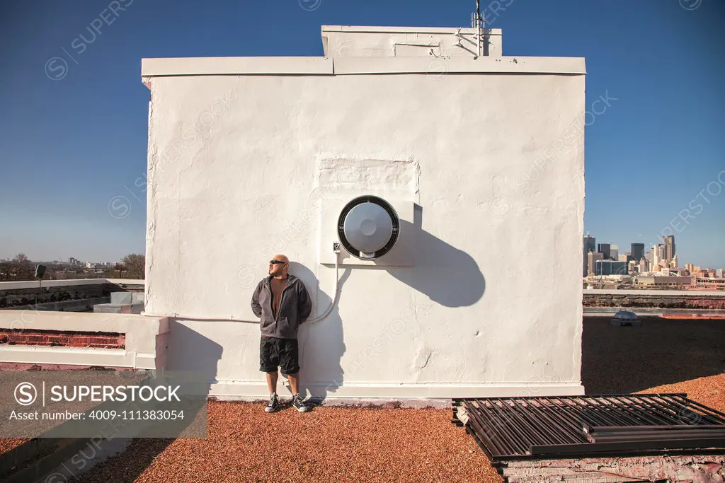 Man leaning on rooftop wall