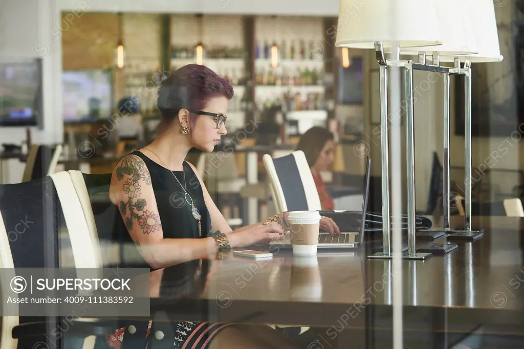 Caucasian woman using laptop in coffee shop