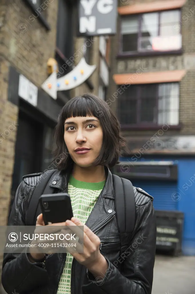 Woman walking the streets of London using mobile phone