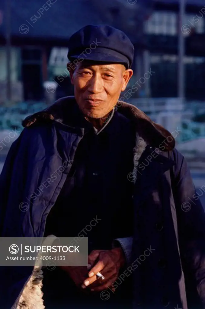 Portrait of an elderly Chinese man holding a cigarette, Datong, China