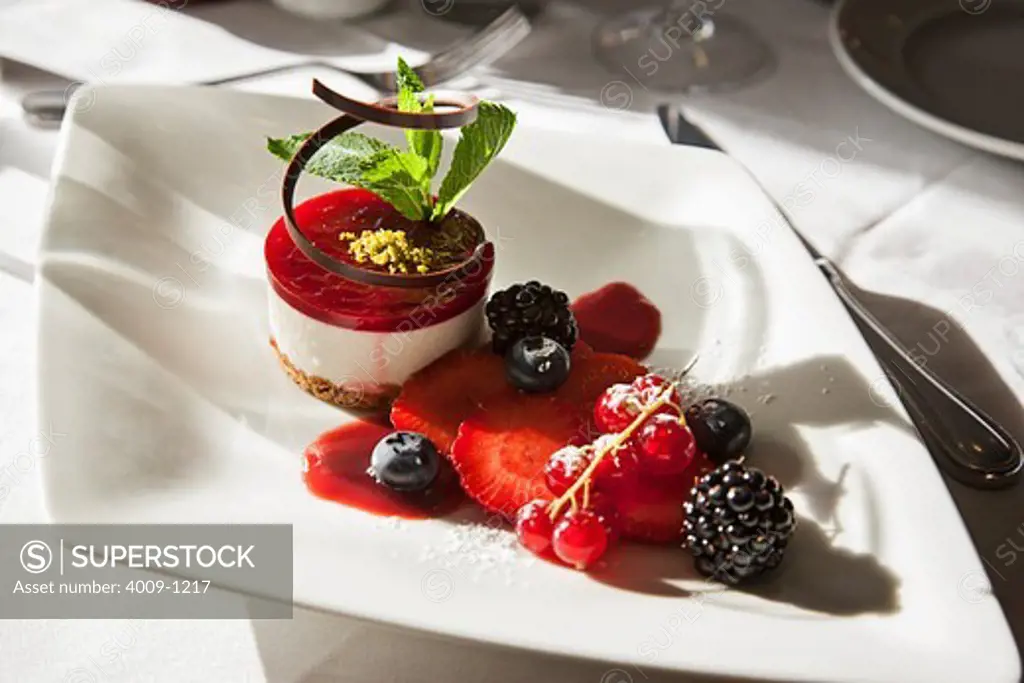 Cheesecake with chocolate and mint garnished with berries served in a plate