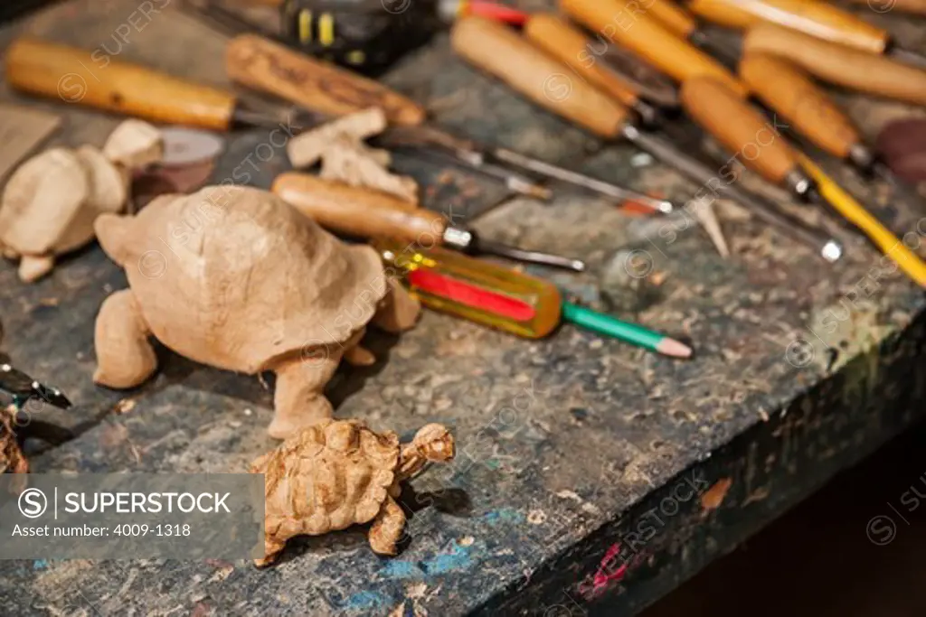 Ecuador, Galapagos Islands, Wooden tortoise sculptures on table in wood carving workshop