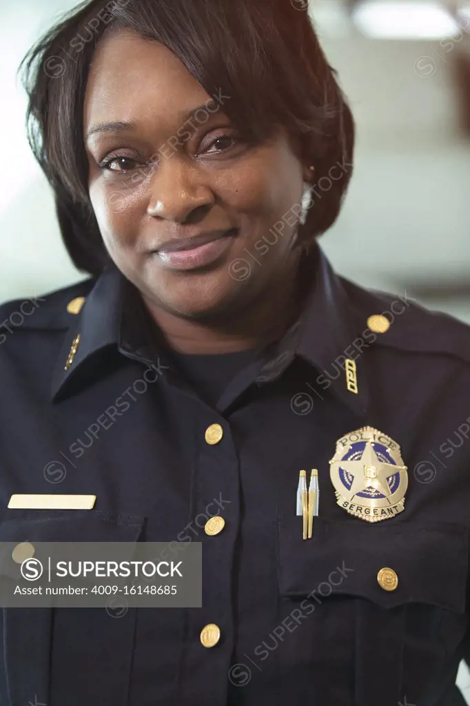 Portrait of Police woman Sergeant standing looking towards camera smiling 