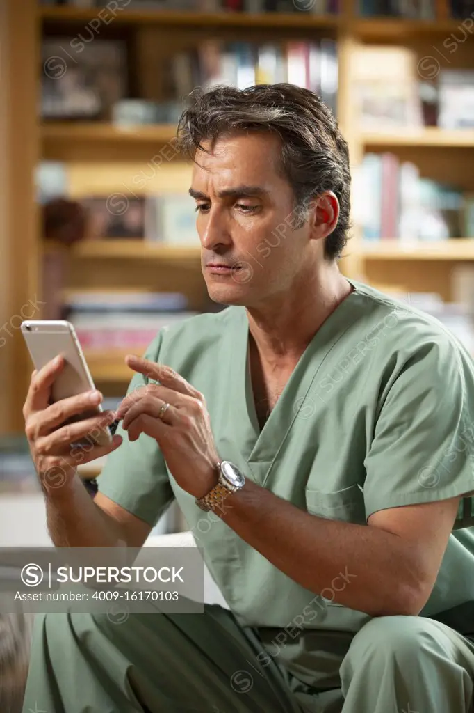 Hispanic Male doctor practicing tele-medicine from his home office, Talking to patient on video call 