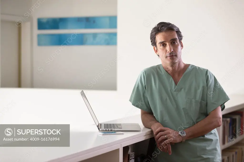 Portrait of Hispanic Male doctor in his home taking a break from practicing Tele-medicine