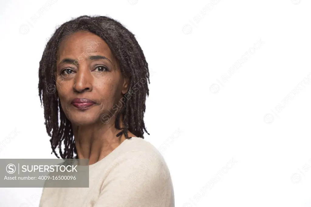 Portrait of older black woman looking at camera over shoulder with straight face 
