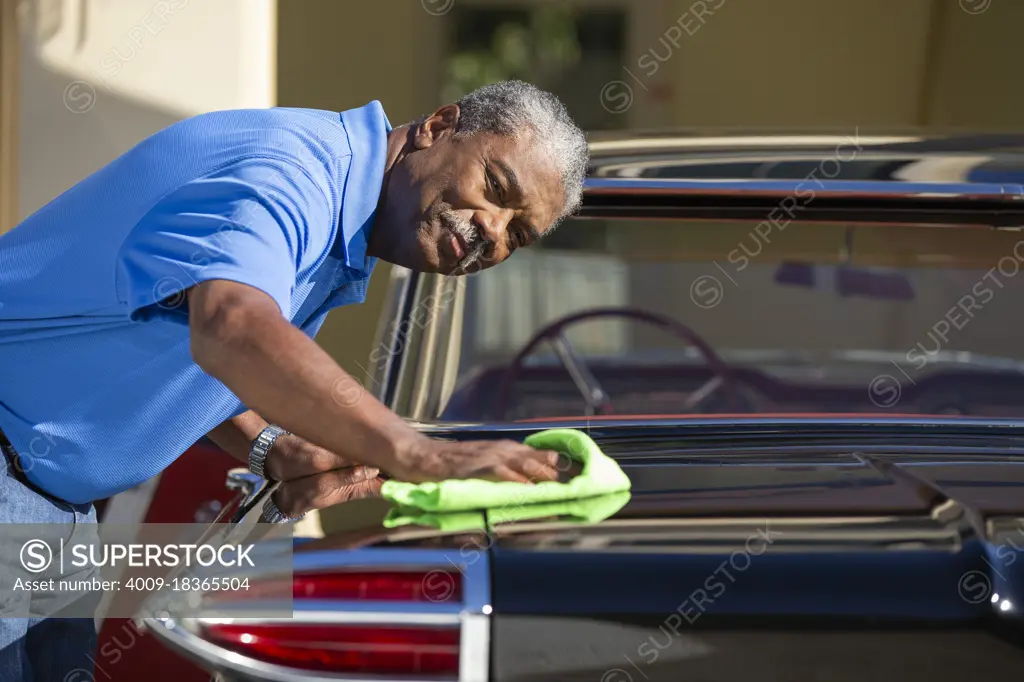 Older man drying off his classic car 