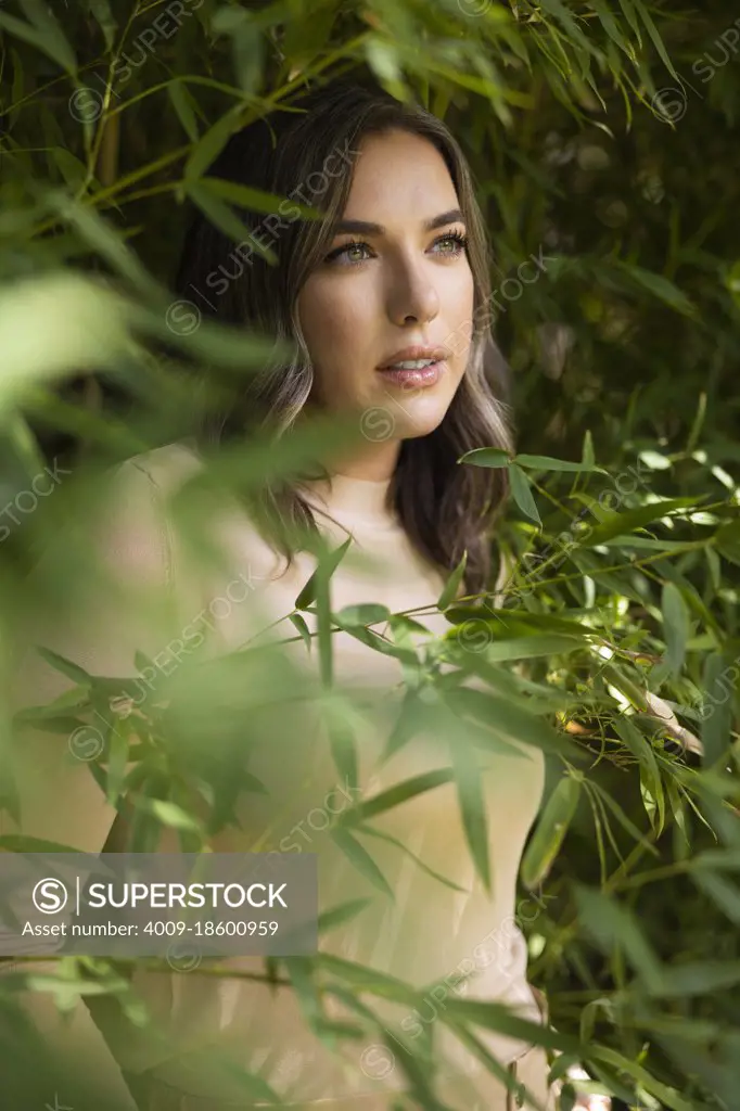 Portrait of caucasian woman  standing among bamboo 