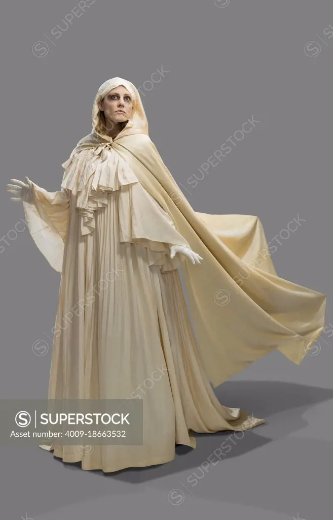 Woman dressed as a ghost in Halloween costume gliding and hovering in frame against gray background