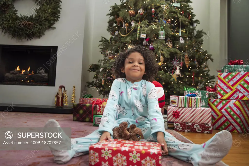 Portrait of surprised girl holding wrapped gift on Christmas