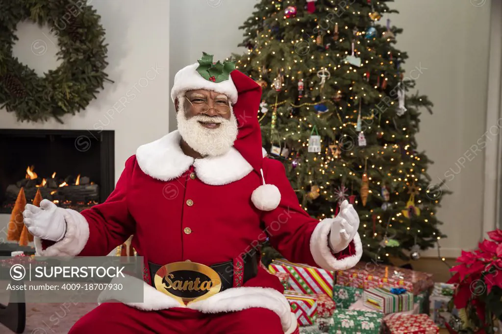 A welcoming Santa Claus sitting in living room looking into camera. Black Santa Series