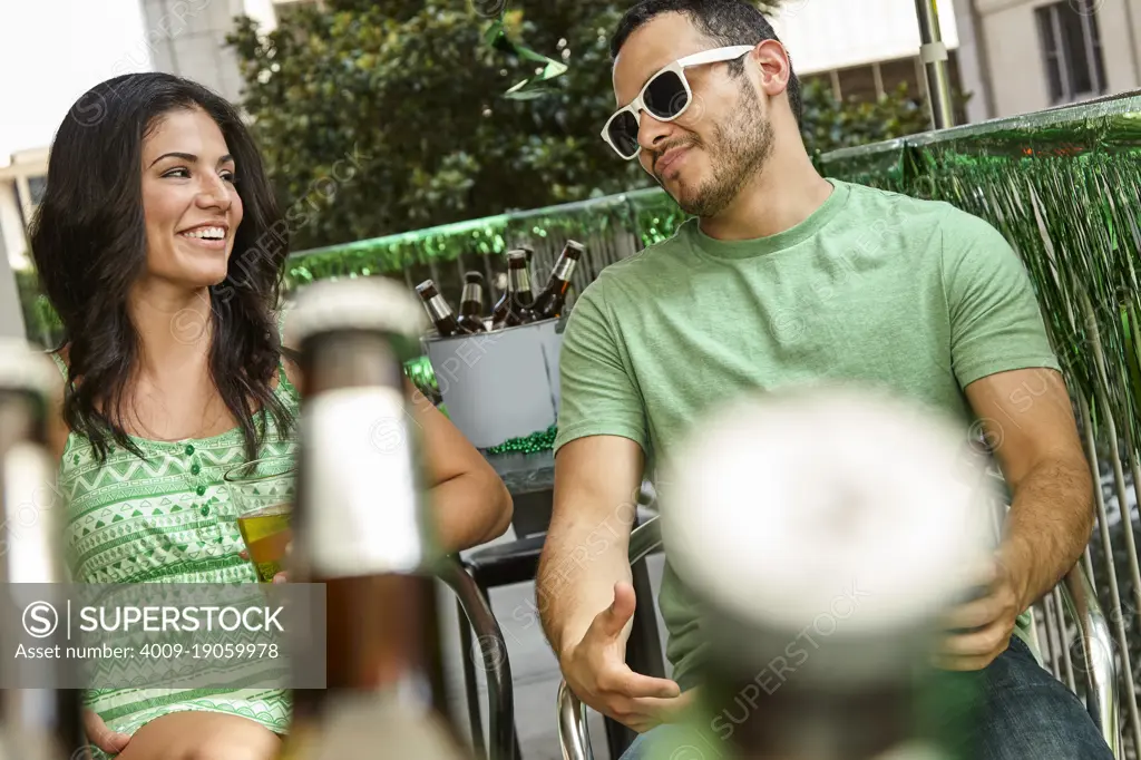 Group of friends hanging out on balcony of bar enjoying St Patrick's Day festivities