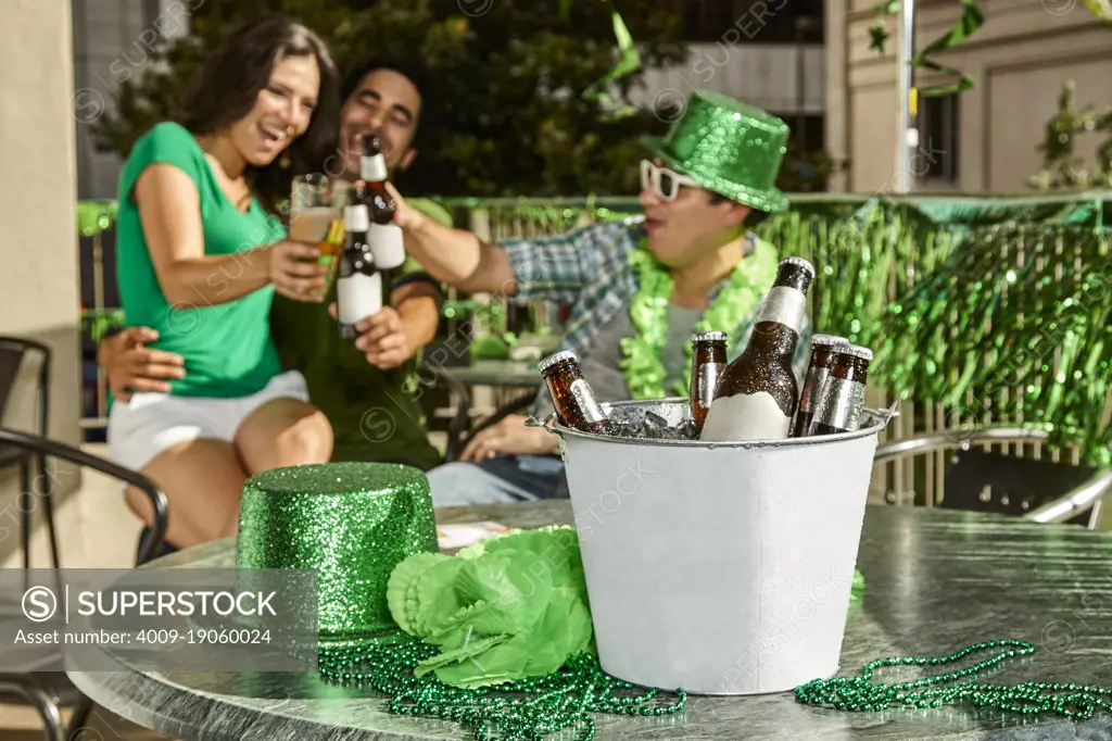 Group of friends toasting in background with a bucket of beer in foreground. Focus on foreground. 