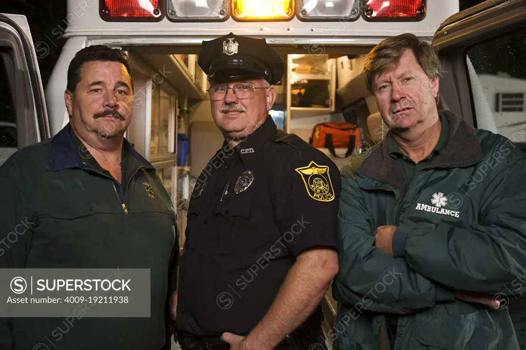 Portrait of EMS & Police first responders standing at back of an open ambulance 
