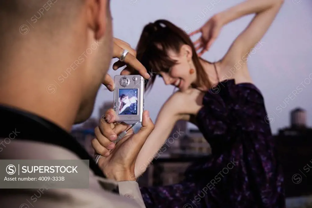 Man taking a picture of his girlfriend with a digital camera, Manhattan, New York City, New York State, USA