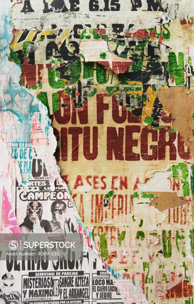 Detail of ripped Lucha Libre posters on a wall, Mexico