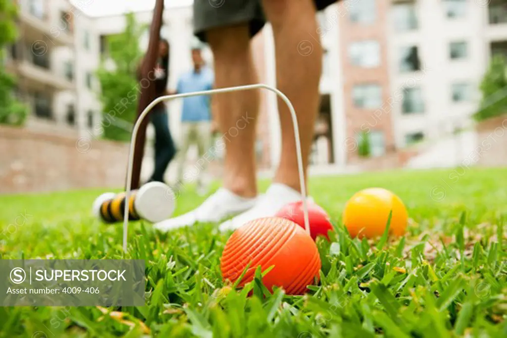 Young man playing croquet in a lawn