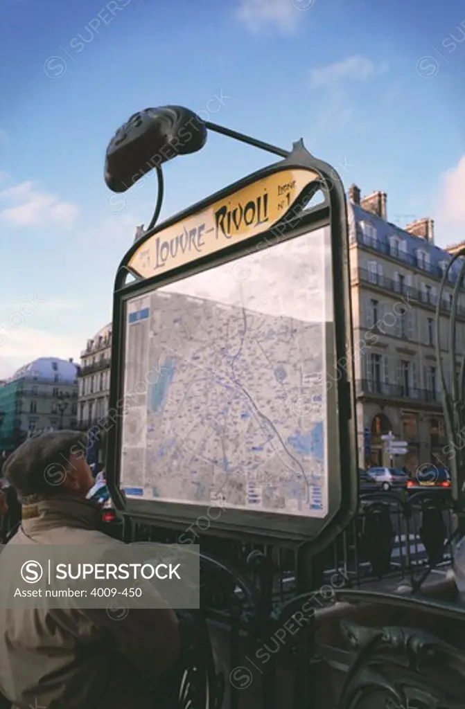 Tourist looking at metro map outside of the metro station, Louvre-Rivoli, Paris, Ile-de-France, France