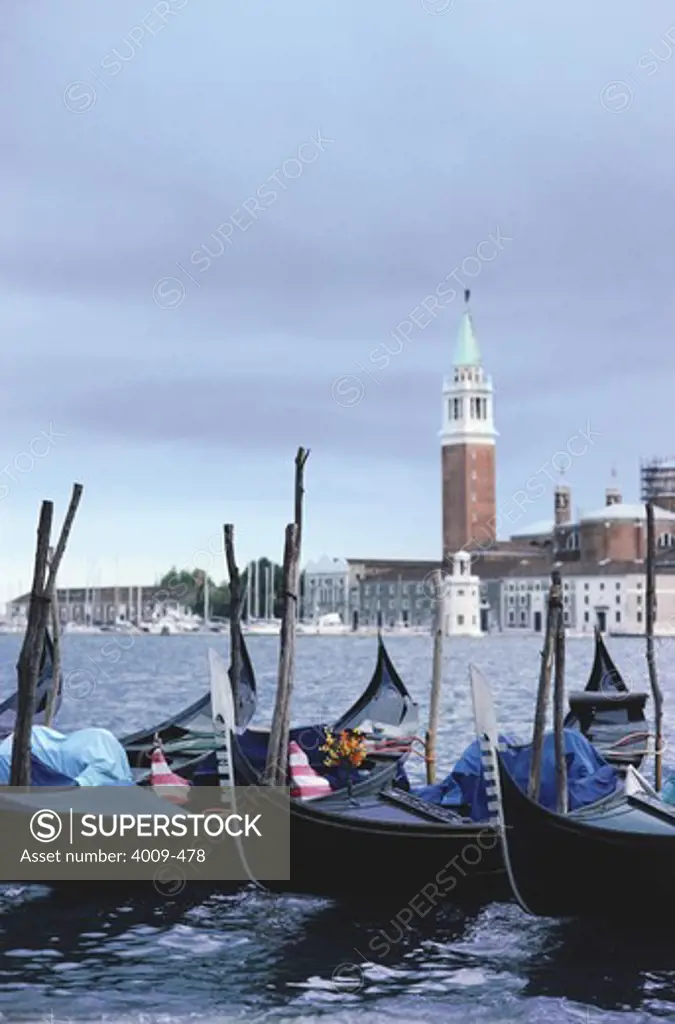 Gondolas moored and bell tower in the background, St Mark's Campanile, Venice, Italy