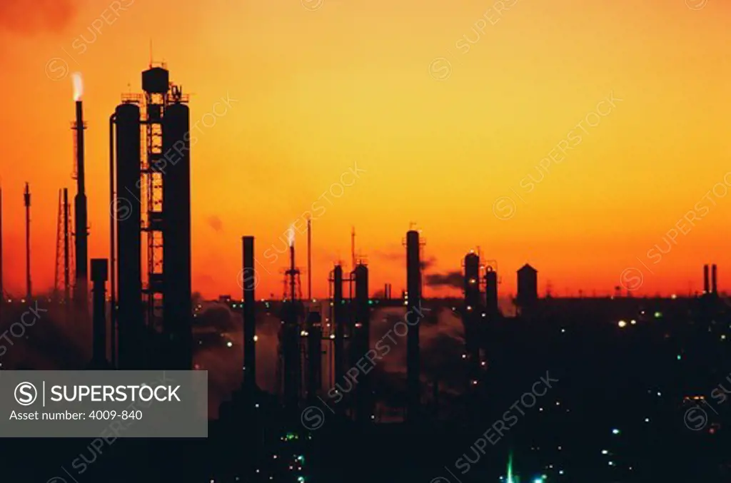 Silhouette of an oil refinery at sunset, Texas, USA