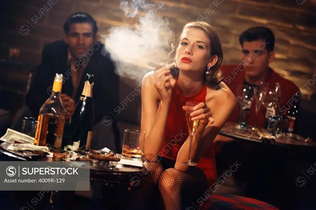 Young woman smoking a cigar in a bar