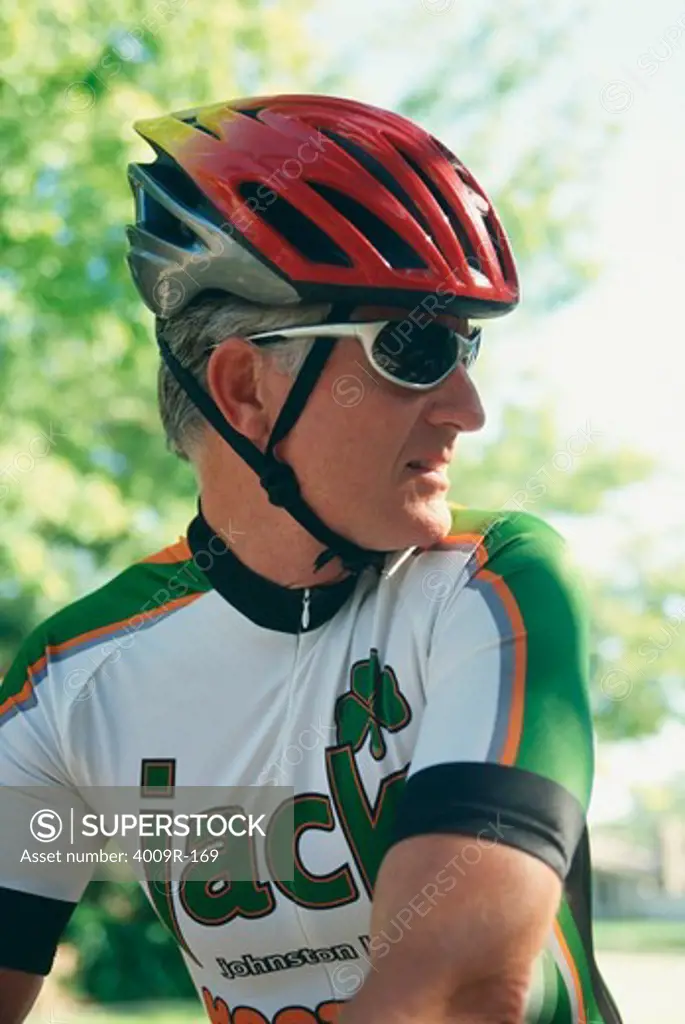 Cyclist wearing a helmet and sunglasses looking sideways