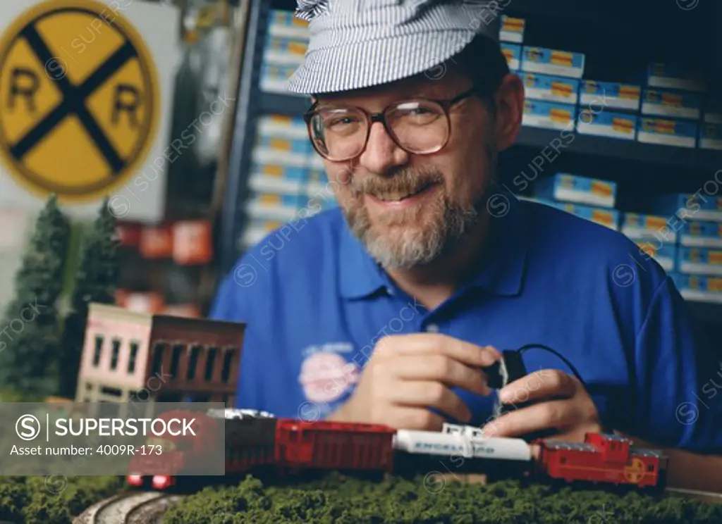 Mature man operating a toy train