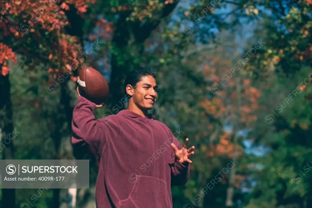 Young man throwing a football in a park