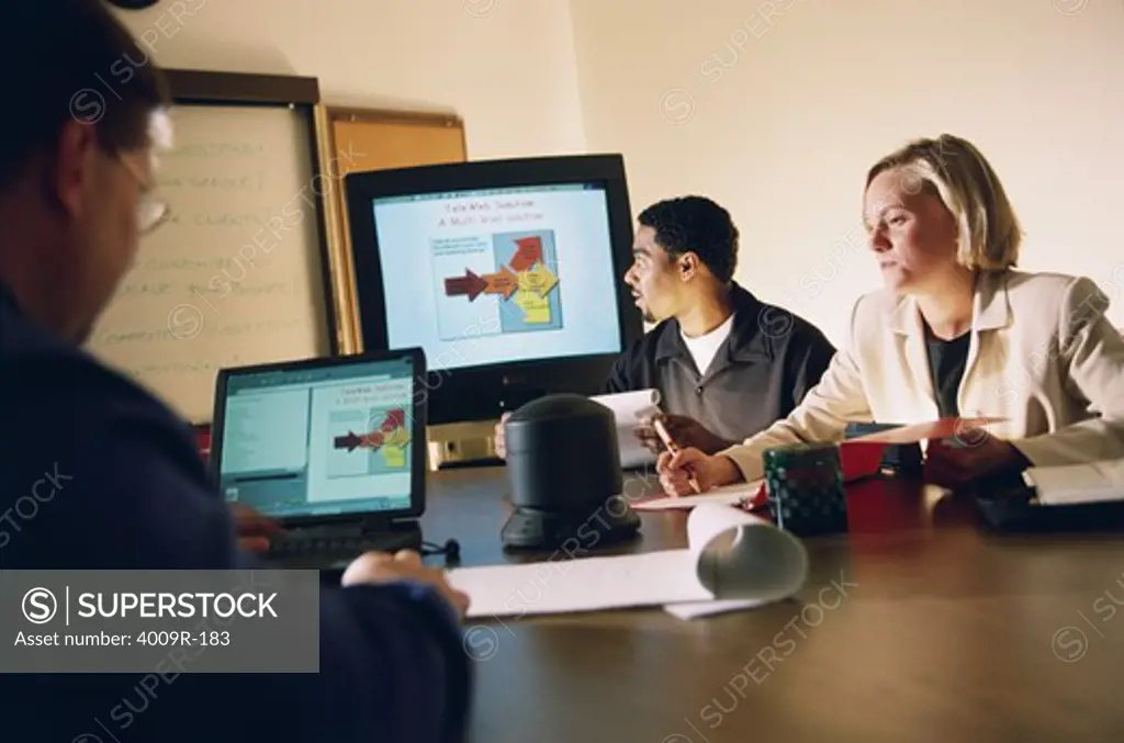 Business executives in a business meeting using computers in a conference room