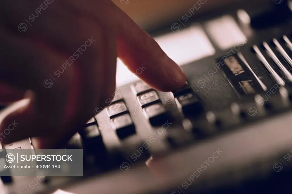 Close-up of a man's hand dialing a phone