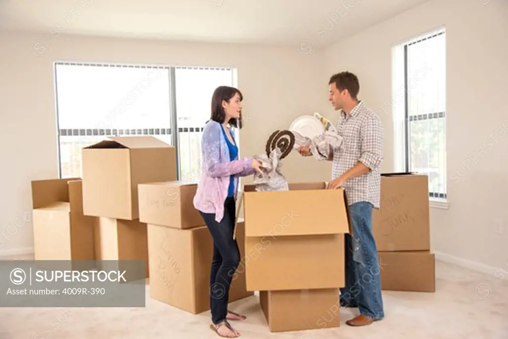 Couple unpacking their belonging as they move into new house