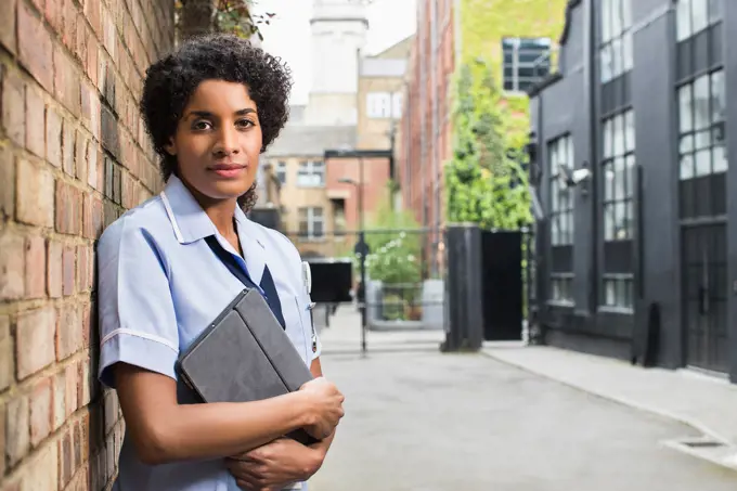 Portrait of Woman in healthcare industry standing in Alley holding ipad