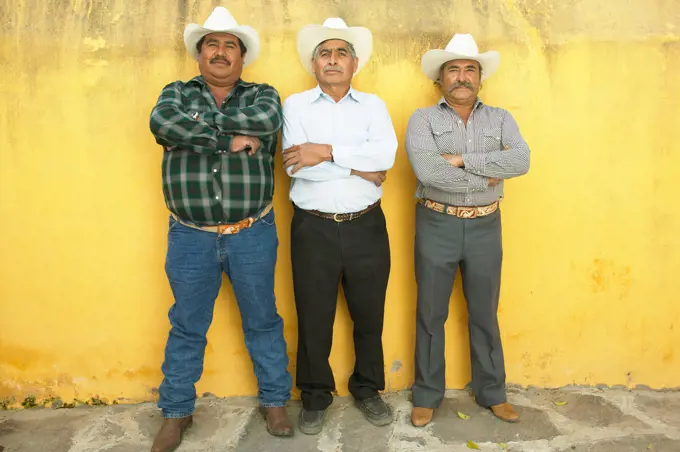Three men standing with arms crossed