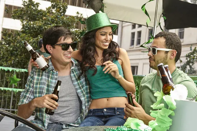 Young woman with her arm around her boyfriend laughing while celebrating St. Patrick's Day