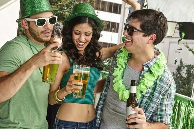 Group of friends hanging out on balcony of bar enjoying the St Patrick's Day festivities