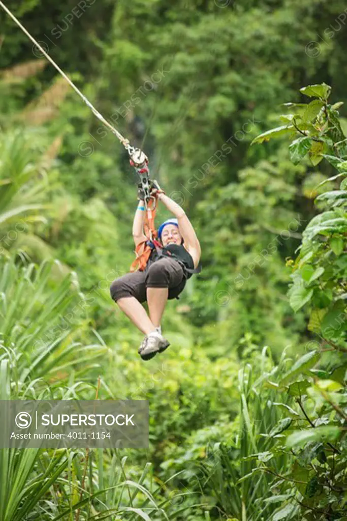 Woman riding a zip line in a forest, Costa Rica