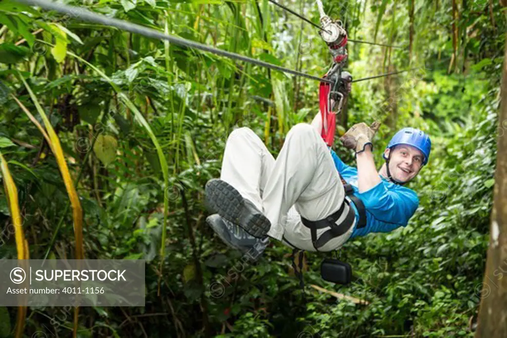 Man riding a zip line in a forest, Costa Rica