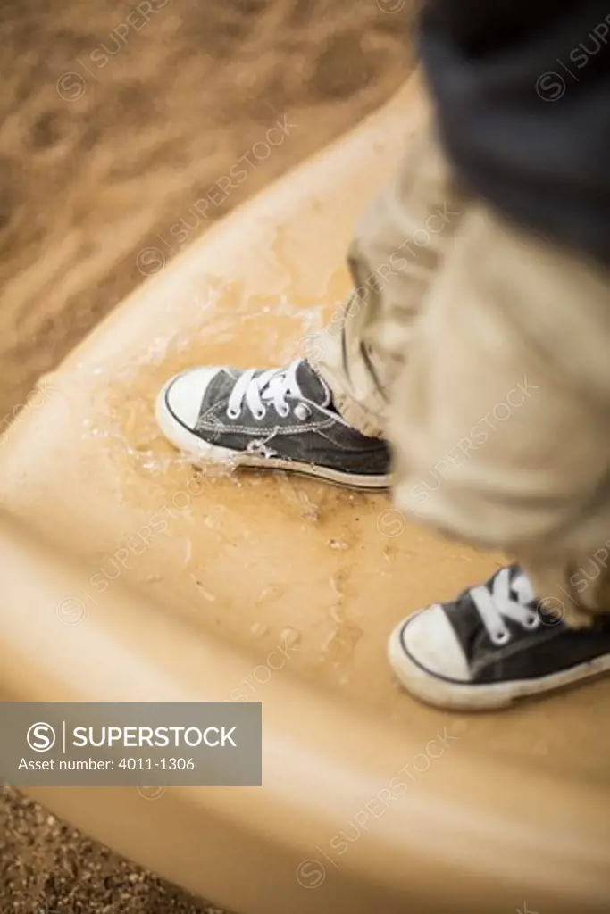Young boy (2-3) jumping in puddle
