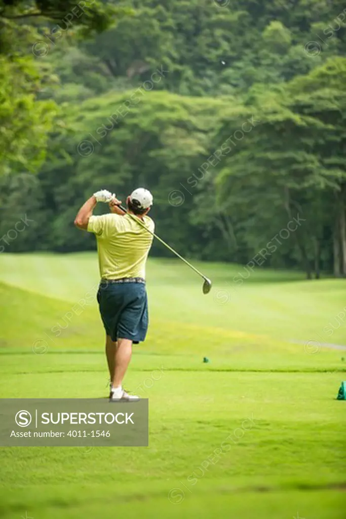 Costa Rica, Los Suenos, Golfer teeing off in Rain Forests of Costa Rica