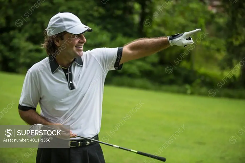 Costa Rica, Golfer smiling and pointing his finger down  fairway