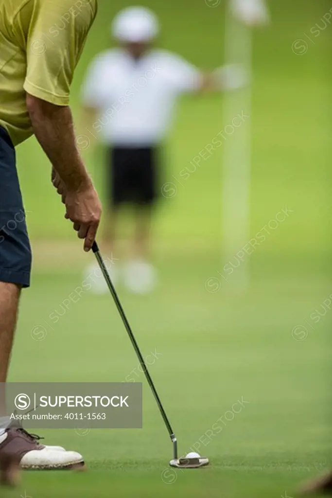 Costa Rica, Golfer tending to  flag while his partner putting
