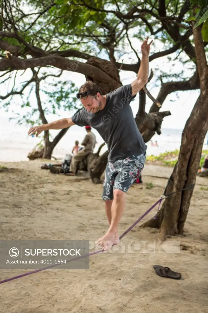 Costa Rica, Tourist walking slackline on beach