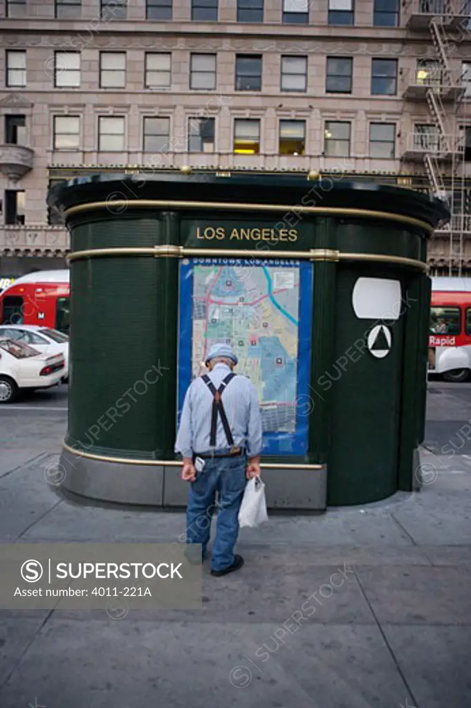 USA, California, Los Angeles, Old Man with suspenders looking at map of Downtown
