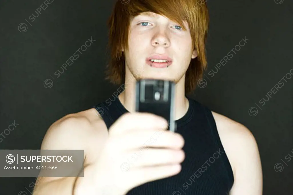 Teenage boy taking a picture with a camera phone