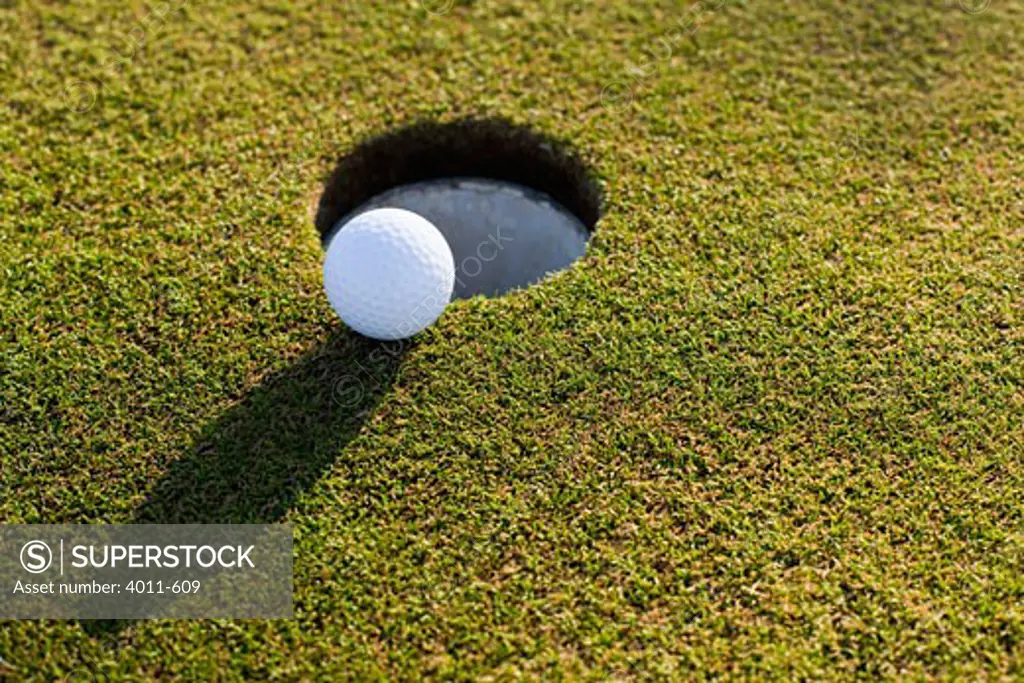 Close-up of a golf ball near a hole