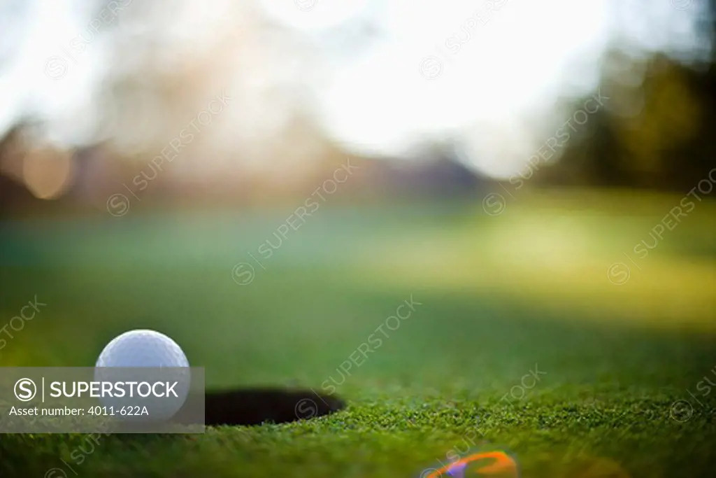 Close-up of a golf ball near a hole