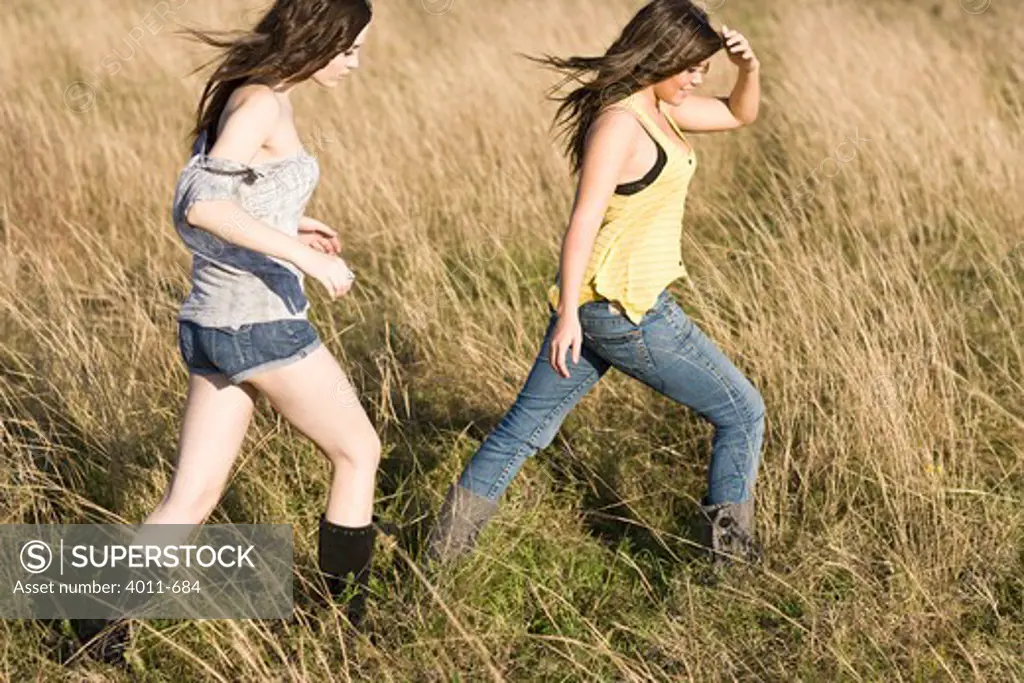USA, Texas, two teenage girls walking in meadow