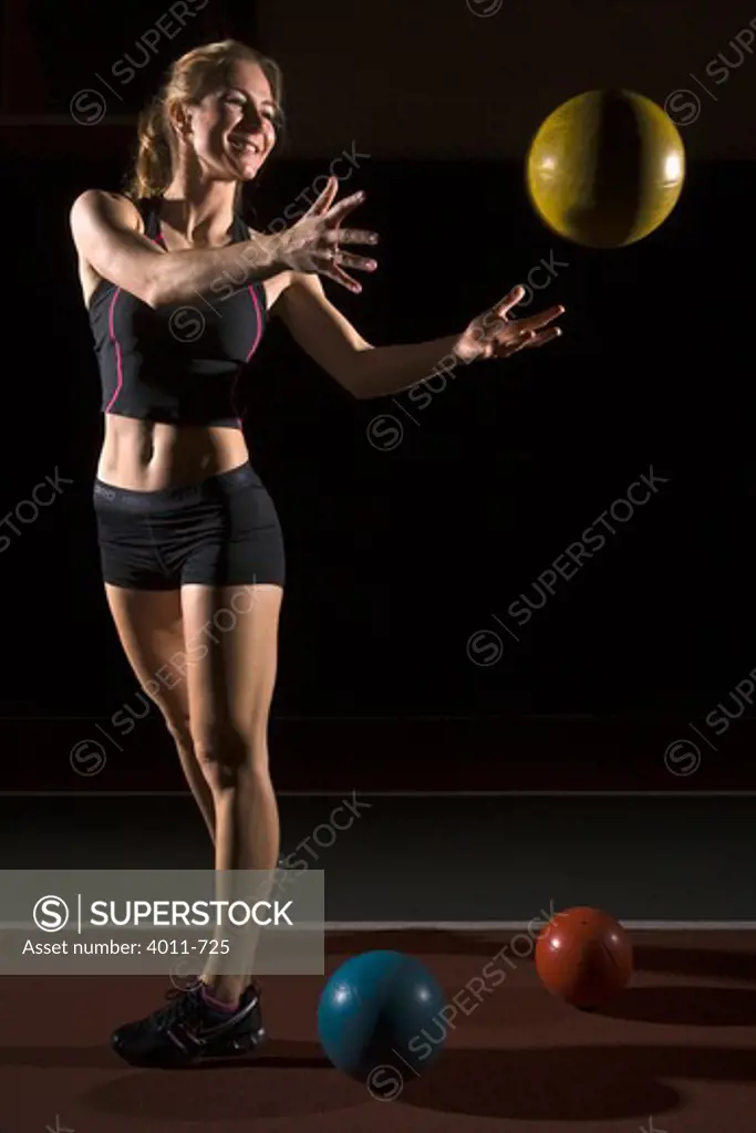 Young fit woman throwing weight ball