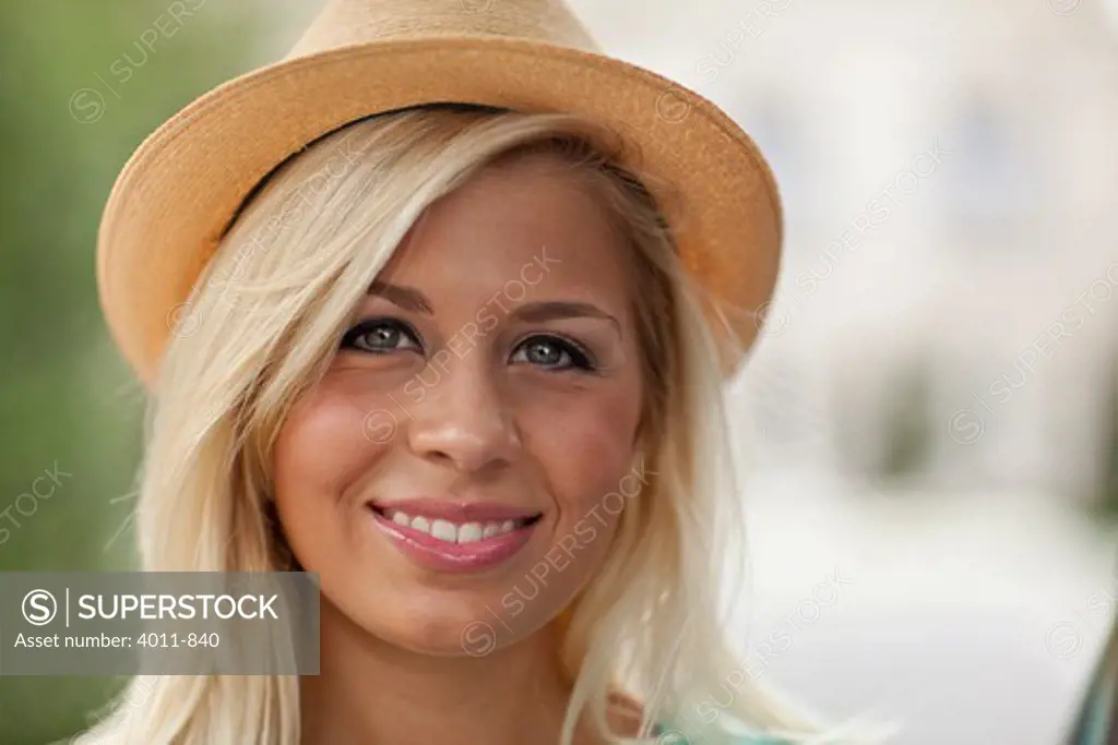 Portrait of smiling young woman wearing straw hat